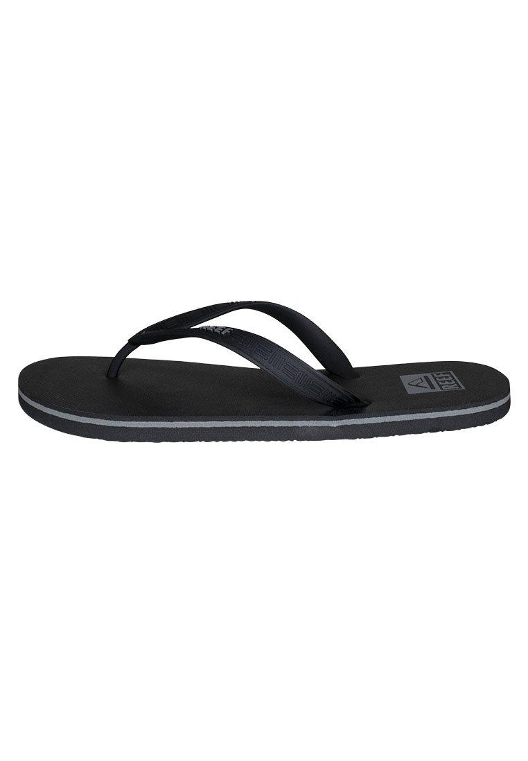 Tongs noires avec des brides texturées et une semelle en caoutchouc plate. Présentent une bande d'accent grise le long du bord et un logo sur la semelle intérieure.