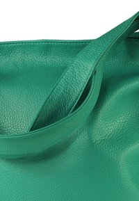 Turkooizen lederen totebag met een gestructureerde afwerking, voorzien van een brede band en een zachte, slappe vorm. Geen zichtbare metalen onderdelen of versieringen.