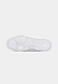 Hvit sneakersåle med ribbet design, med fiskebeinsmønster og sirkulære detaljer. Glatt tekstur, laget av gummimateriale.