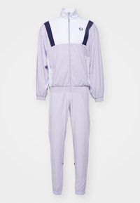 Hellpurpurner Trainingsanzug aus glattem Stoff. Verfügt über eine Jacke mit Reißverschluss, hohem Kragen und marineblauen Akzenten sowie passende, schmal zulaufende Hosen.