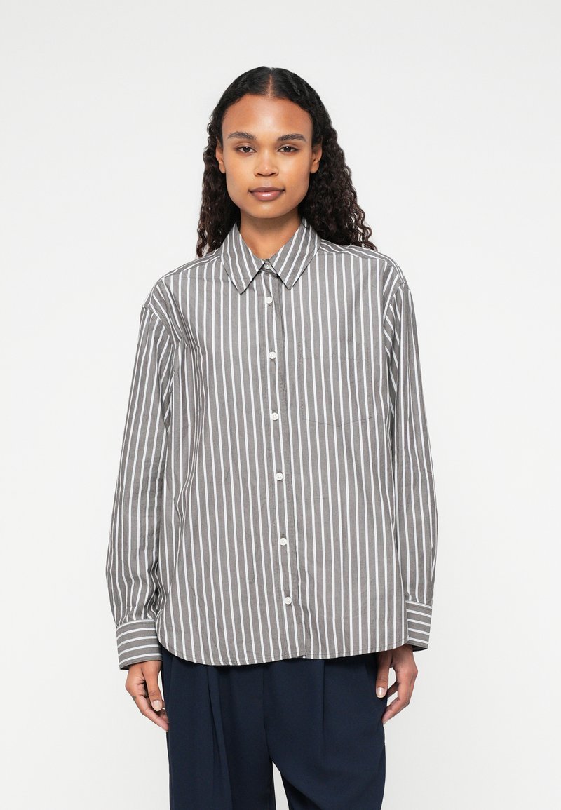 Camicia a righe grigia e bianca, realizzata in tessuto leggero. Dotata di colletto, maniche lunghe e tasca sul petto.