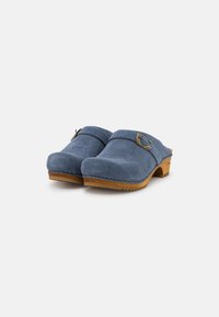 Zoccoli blu in suede con suole in legno, punte arrotondate e una fascia laterale con un accento metallico decorativo. Superficie testurizzata con dettagli di cucitura.
