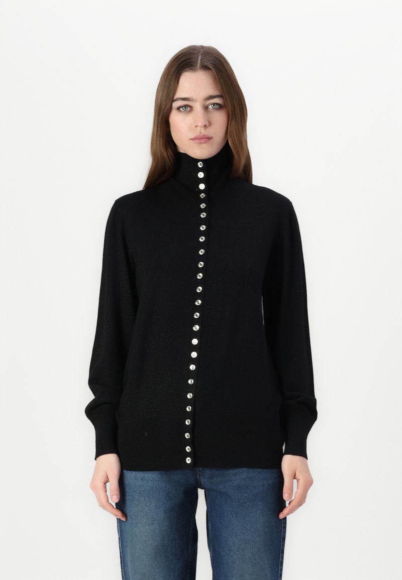 Maglione nero a maglia con colletto alto, caratterizzato da una linea centrale di bottoni argentati lucidi, maniche lunghe e una vestibilità aderente.