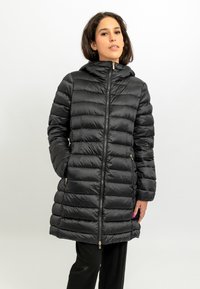 Zwarte donsjas met capuchon, voorzien van een gequilt ontwerp, een rits aan de voorkant en zijzakken. Glad, glanzend materiaal met gouden hardware accenten.