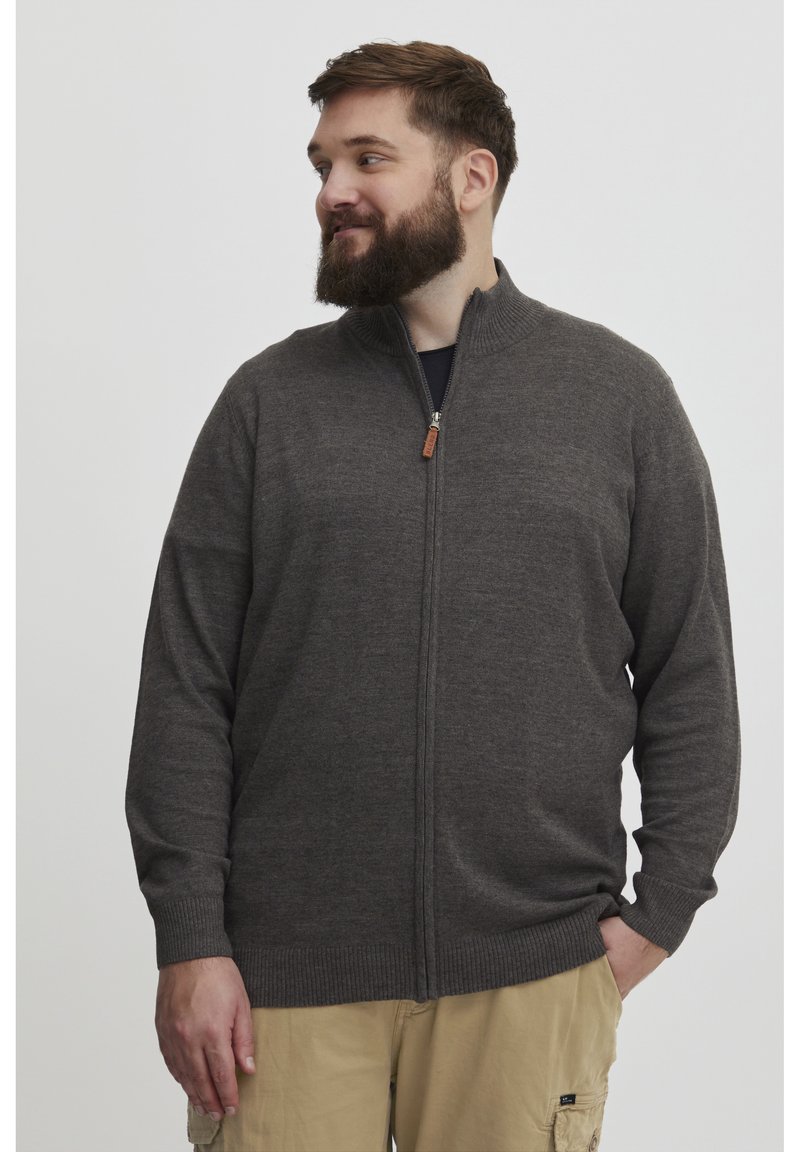 Cardigan gris con cremallera y alto cuello, puños y bajo acanalados. Hecho de una tela suave, presenta una pequeña lengüeta de cuero en la cremallera.