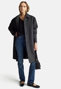 Abrigo de lana gris con cuello de muesca, combinado con jeans oscuros, bailarinas negras y un pequeño bolso negro. Detalles en accesorios plateados.