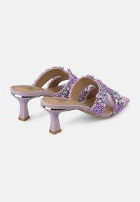 Mules violets à talons avec une tige en tissu texturé ornée de pierres décoratives multicolores, bout pointu et talon aiguille élancé.