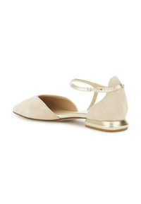 Beige Wildleder Ballerinas mit spitzem Zehenbereich, goldenem metallischen Absatz und Knöchelriemen. Weicher Stoff mit minimalistischem Design und seitlichen Ausschnitten.