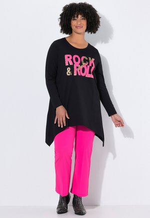 T-shirt à manches longues noir avec "ROCK & ROLL" imprimé en rose et imprimé léopard, associé à un pantalon rose vif et des bottines noires à clous.