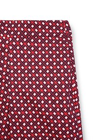 Leggings multicolor con un motivo geometrico di diamanti rossi, blu navy e bianchi. Realizzati in tessuto elasticizzato con una consistenza liscia.