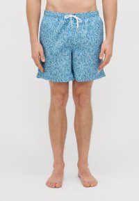 Sinised ujumispüksid, millel on tekstuuriga lillemuster. Omavad elastset pihaosa koos valge paelaga ja on laia lõikega.