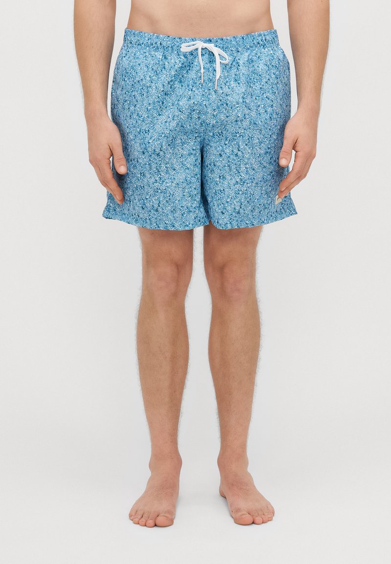 Sinised ujumispüksid, millel on tekstuuriga lillemuster. Omavad elastset pihaosa koos valge paelaga ja on laia lõikega.