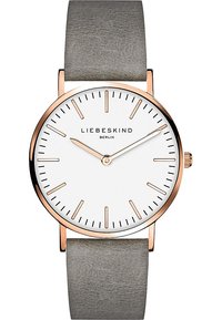 Runde Uhr mit Zifferblatt in Weiß, roségoldenen Akzenten, schmalem grauen Lederarmband, minimalistischen Stundenmarkierungen und einer kleinen Krone zur Einstellung.