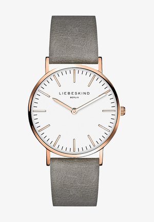 Runde Uhr mit Zifferblatt in Weiß, roségoldenen Akzenten, schmalem grauen Lederarmband, minimalistischen Stundenmarkierungen und einer kleinen Krone zur Einstellung.