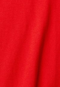 Tissu rouge vif avec une surface douce, légèrement texturée et des plis légers indiquant un matériau léger.