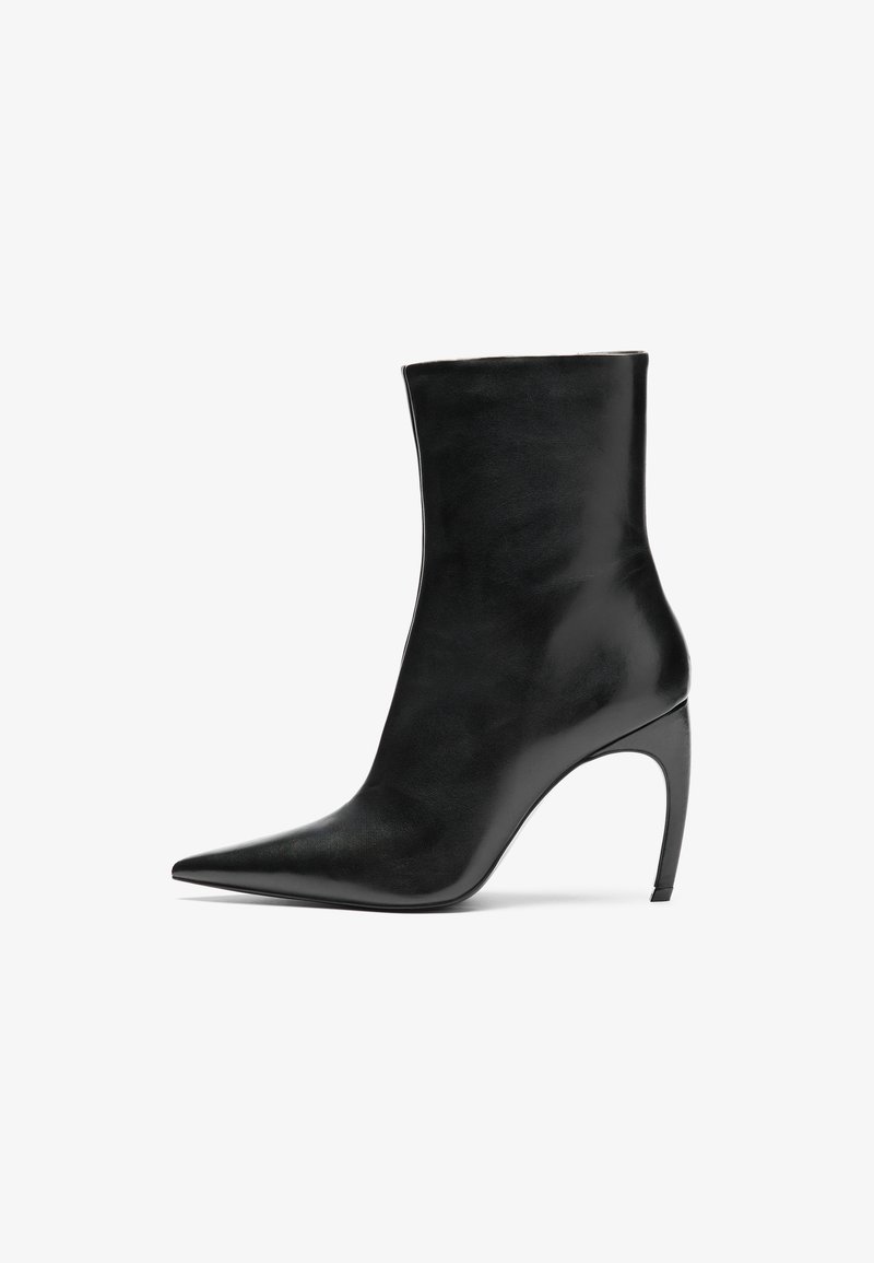 Bottine en cuir noir avec un bout pointu et un talon aiguille haut. Sa texture lisse et son design minimaliste mettent en avant une élégance moderne.