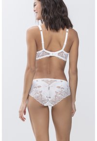Weiße Spitzen-BH- und Slip-Set mit floralen Mustern, verstellbaren Trägern und einer weichen Textur. Das Design umfasst gewellte Kanten und einen Hakenverschluss.