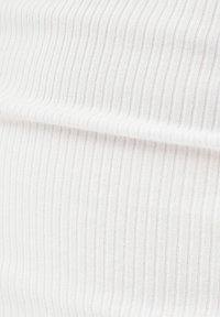 Tissu blanc côtelé avec de fines rayures verticales ; texture douce et qualité extensible. Aucun motif ou élément matériel notable présent.