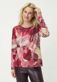 Top met lange mouwen met een meerkleurig bloemenpatroon in tinten rood en roze, met een contrasterende gestreepte halslijn en een losse pasvorm.