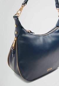 Granatowa skórzana torebka o gładkiej fakturze, z złotymi elementami ozdobnymi i zamkiem błyskawicznym. Krągły kształt z pojedynczym paskiem na ramię.