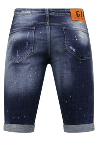Donkerblauwe denim shorts met een versleten afwerking, voorzien van lichte verfspatjes, opgerolde boorden en een merklabel in oranje aan de tailleband.