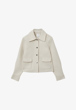 Veste courte de couleur crème avec un col à revers, boutonnage à l'avant, deux poches plaquées et une coupe structurée. Texture du tissu tissé visible.