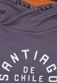 Hooded sweatshirt in donkergrijze stof, met witte tekst "SANTIAGO DE CHILE", oranje binnenvoering en donkerblauwe trekkoord met patroonaccenten.