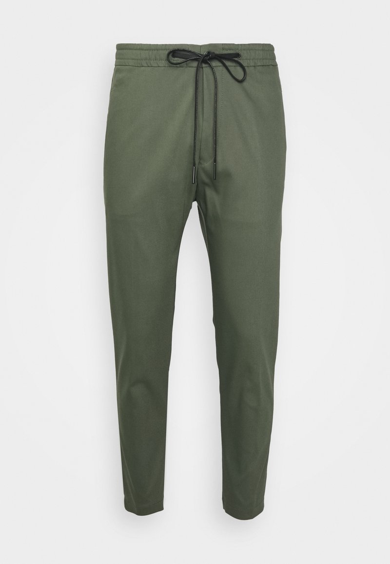 Olijfgroene casual broek met elastische tailleband en zwarte trekkoord, taps toelopende benen, tegen een witte achtergrond.