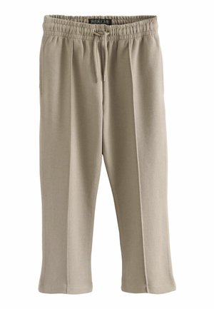 Beige sportsbukser lavet af blødt stof. Har en elastisk talje med snor, sidelommer og en tapered ben-design.