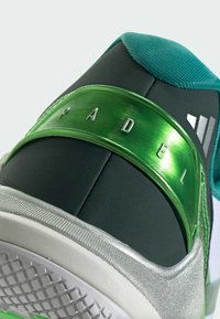 Green and black sneaker with a metallic green accent, featuring a prominent "PADEL" branding, textured upper, and white sole with grip pattern.