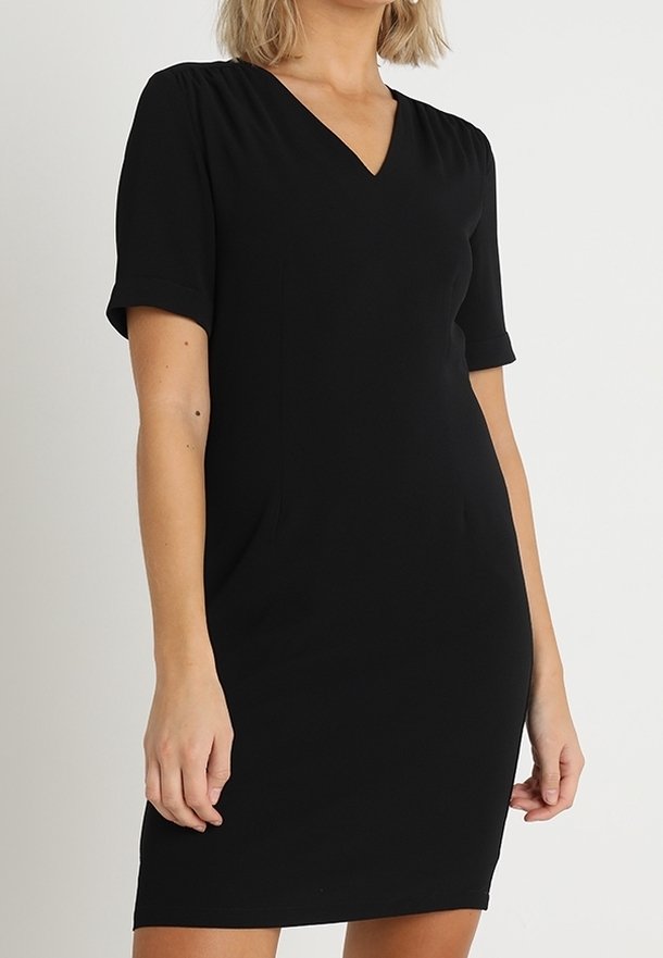 Svart kortärmad klänning med V-ringning, med en figurnära silhuett och mjukt, lätt tyg. Inga mönster eller dekorationer.