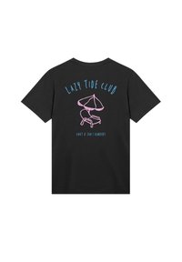 Black T-shirt with blue text "LAZY TIDE CLUB," a pink beach chair and umbrella graphic, and smaller blue text "KNUT & JAN | HAMBURG" on back.