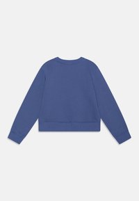 Felpa cropped di un blu intenso. Presenta un collo rotondo e polsini a costine. Realizzata in un tessuto morbido e testurizzato con un design a schiena piatta.
