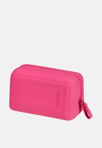 Custodia rigida rettangolare rosa con superficie testurizzata, chiusura a zip e nome del marchio in rilievo, progettata per resistenza e organizzazione.
