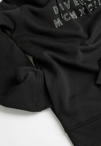 Czarna bluza z kapturem z tekstowym wzorem, wykonana z miękkiego materiału, z ściągaczami na rękawach i u dołu. Tkanina ma gładkie wykończenie, idealna na codzienne noszenie.