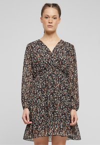 Black floral dress with long sleeves, V-neck, and gathered waistline. Features multi-colored small floral print and sheer, lightweight fabric.