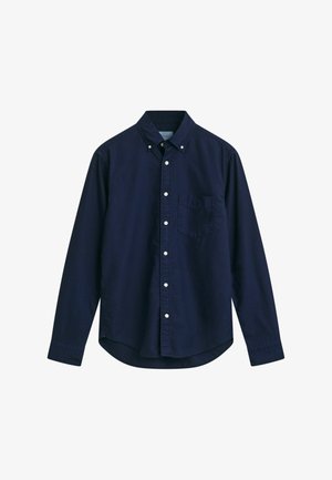 Námořnická modrá košile na knoflíky z bavlněné tkaniny; má límec na knoflíky, dlouhé rukávy a náprsní kapsu. Hladká textura, klasický design.