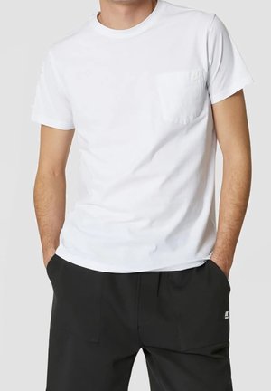 T-shirt bianco in cotone con collo rotondo, maniche corte e taschino sul petto con un piccolo logo. Texture liscia e design aderente.