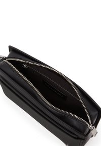 Portafoglio in pelle nera con chiusura a doppia zip, interno testurizzato, hardware in argento e design sottile. Presenta dettagli di cucitura e tasca interna.