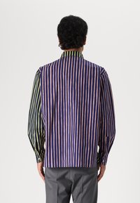 Camisa multicolorida con rayas verticales en azul marino, rosa y verde. Mangas largas, puños abotonados y un diseño de cuello en contraste.
