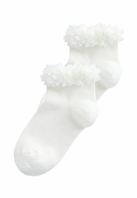 Fehér boka zokni puha szövetvirágokkal díszítve a szegélyén, egy egyszínű fehér háttéren laposan elhelyezve.