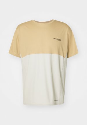 Short-sleeve t-shirt featuring a beige upper section and white lower section, made of textured fabric with Columbia logo on the chest.