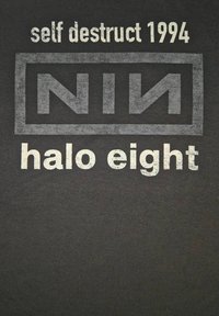 Zwarte t-shirt met witte tekst die "self destruct 1994" en "NIN halo eight" zegt, met een rechthoekig logo om "NIN".