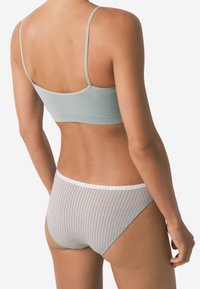 Lys blå bralette med tynde stropper, parret med stribede grå briefs. Elastisk talje med hvid og rød detaljering. Blød tekstur.