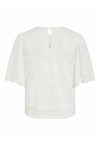 Blouse en dentelle blanche avec manches courtes larges et volantées et petite ouverture en clé à l'arrière du col.