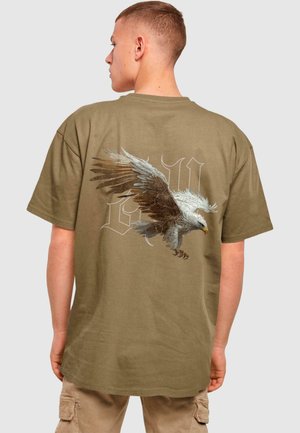 Oliven grøn bomulds t-shirt med et stort ørne-grafik på ryggen, detaljeret vingedesign og stiliseret tekstoverlæg. Løs pasform.
