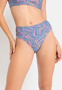 Visoko pasen bikini hlačke v modri barvi z geometrijskim vzorcem, ki vsebuje stripe in trikotnike v rožnatih in oranžnih odtenkih. Gladek tekstil.