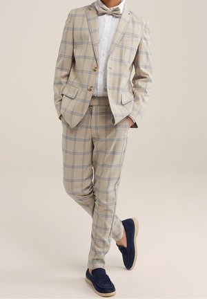 Costume à carreaux léger en beige et bleu clair avec deux boutons, assorti à une chemise blanche et des mocassins en suede bleu marine. Noeud papillon inclus.