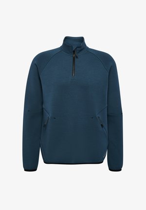 Donkerblauwe fleece pullover met een hoge kraag, halve ritssluiting aan de voorkant en ritszakken aan de zijkant. Heeft raglanmouwen en een gebogen zoom.