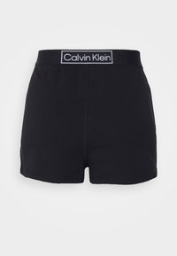 Fekete pamut rövidnadrág, elasztikus derékkal, fehér "Calvin Klein" logóval. Simább anyag és könnyed dizájn, minta nélkül.